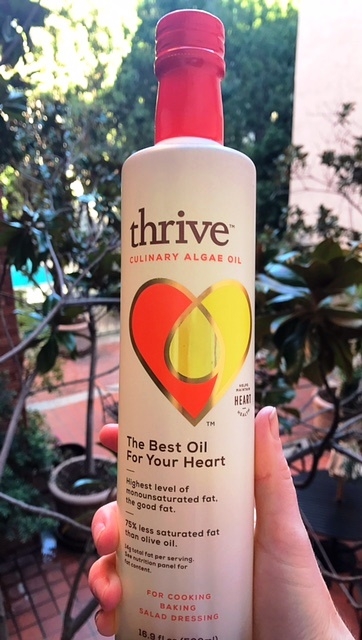 hand holding bottle of thrive culinary algae oil