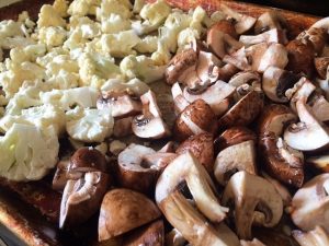 sheet pan with cauliflower and mushrooms to be roasted