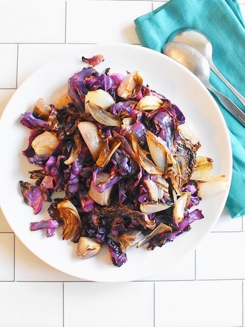 roasted red cabbage and shallots with hard apple cider glaze on white tile background