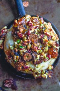 baked brie with nuts and jam in black dish