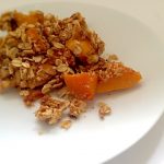 Persimmon ginger almond and oat crisp on a white plate
