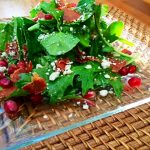 Winter Salad with Pomegranate, Blue Cheese and Prosciutto Crisps on glass plate and woven mat