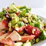 tuna kale edamame strawberry salad on a white plate
