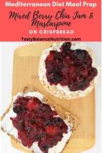bamboo cutting board withcrispbread and brown rice cake topped with mixed berry chia jam and mascarpone cheese