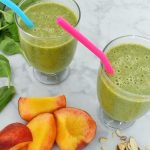 green smoothie with spinach, sliced peaches, banana, and sliced almonds