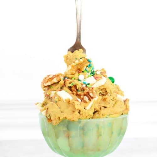 cookie dough hummus in green bowl with spoon sticking out of top