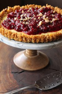 Orange cranberry breakfast tart on a marble cake stand